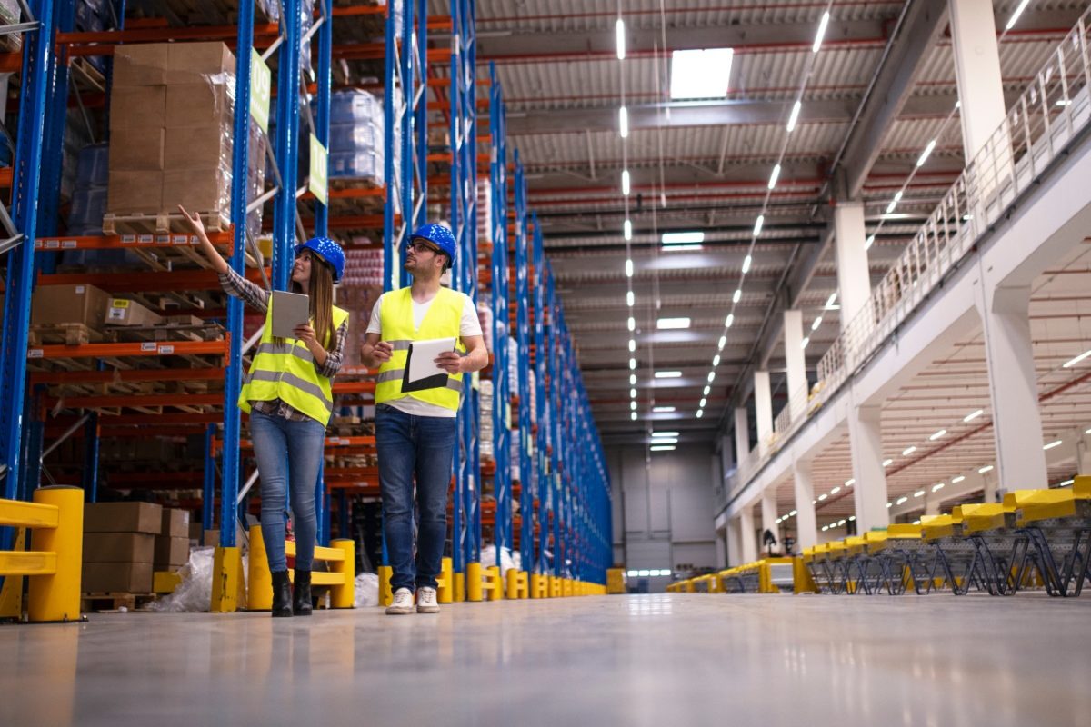 Workers in a big warehouse facility full of inventories