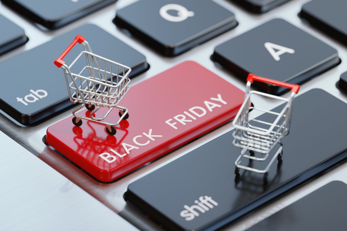Modern computer keyboard with a shopping carts and a red Black Friday button.  Horizontal composition with selective focus and copy space. Great use for shopping and Cyber Monday related concepts.