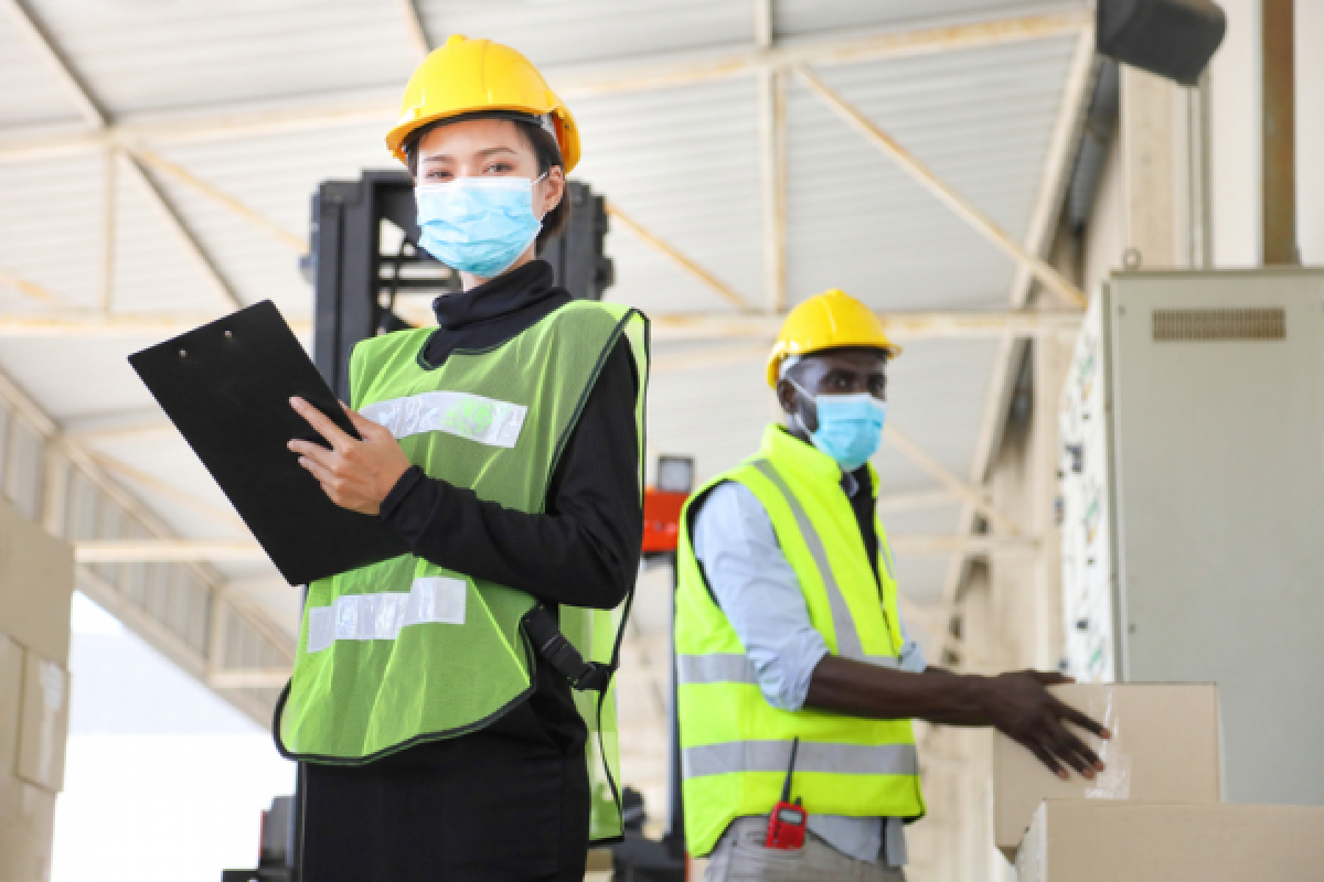 Engineers wearing facemask working on a warehouse